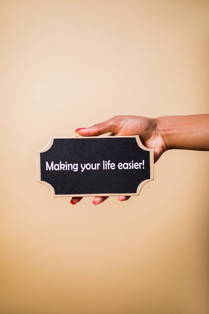 Close-up of a hand holding a sign that reads Making your life easier. Perfect for motivational content.