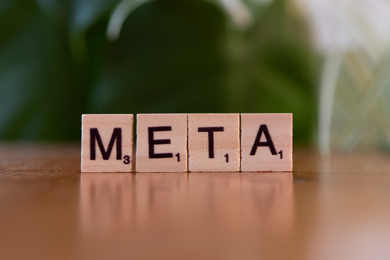 Offerings Wooden letter blocks spell META on a table with a blurred green background.
